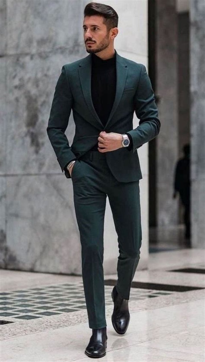 a man in a suit and tie posing for a photo